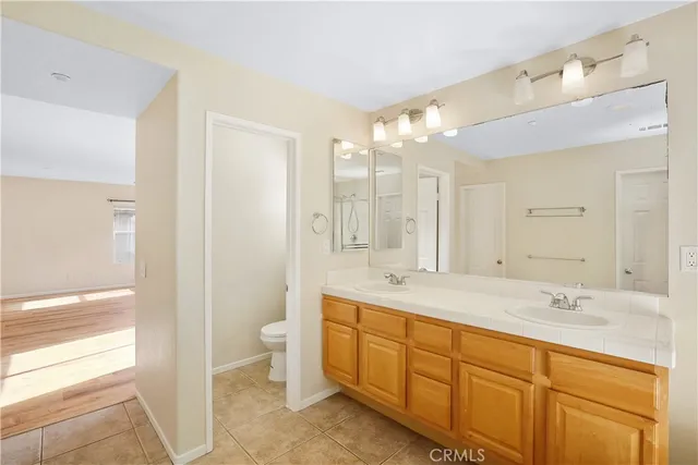 a spacious bathroom with a double vanity sink mirror and toilet