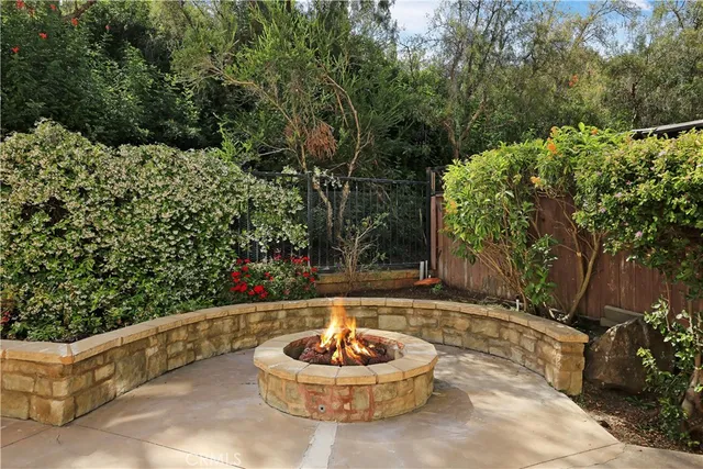 a backyard of a house with fountain table and chairs