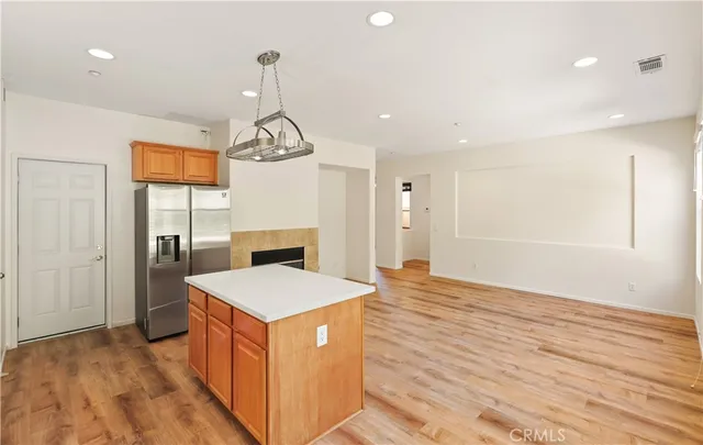 a kitchen that has a lot of cabinets in it with stainless steel appliances granite countertop a stove and a wooden floors