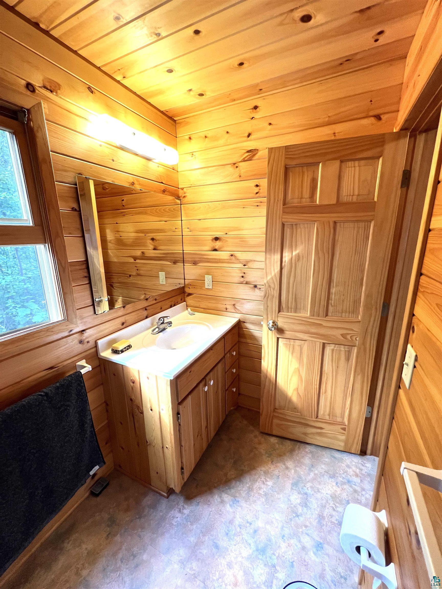 4366 Wood Ridge Drive Two Harbors, MN 55616 - Photo 8 of 21 Bathroom with wooden walls and vanity