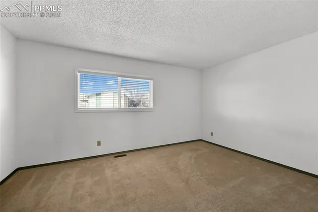 an empty room with closet and windows