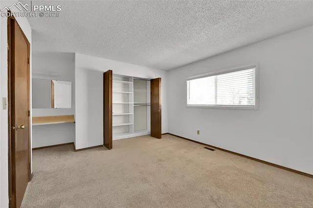 a view of an empty room with a closet