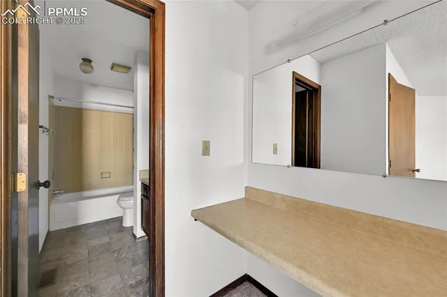 a bathroom with a granite countertop sink and a mirror