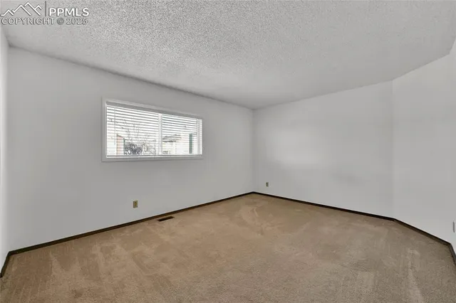 a view of a hallway with wooden floor and a bathroom