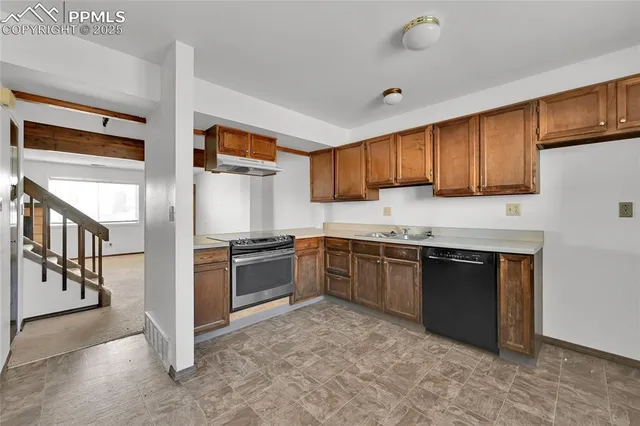 a kitchen with stainless steel appliances granite countertop a stove a sink and a refrigerator