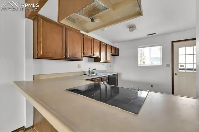 a kitchen with granite countertop a sink and a stove top oven