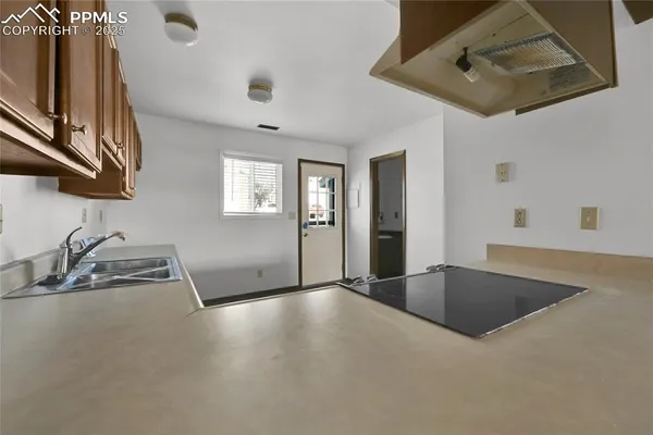 a view of an empty room with a fireplace and a window