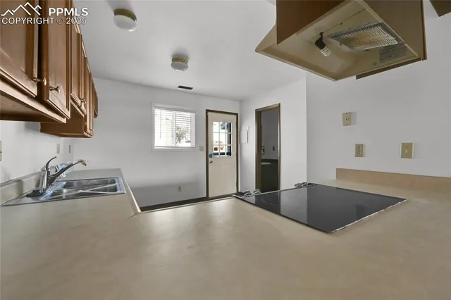 a view of an empty room with a fireplace and a window