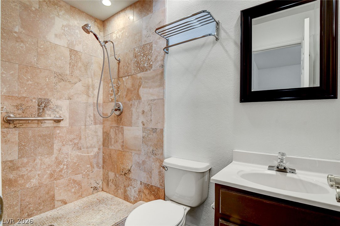 1810 Pinto Road Henderson, NV 89002 - Photo 26 of 53 A functional bathroom showcasing a walk-in shower with tile surround and a convenient vanity.