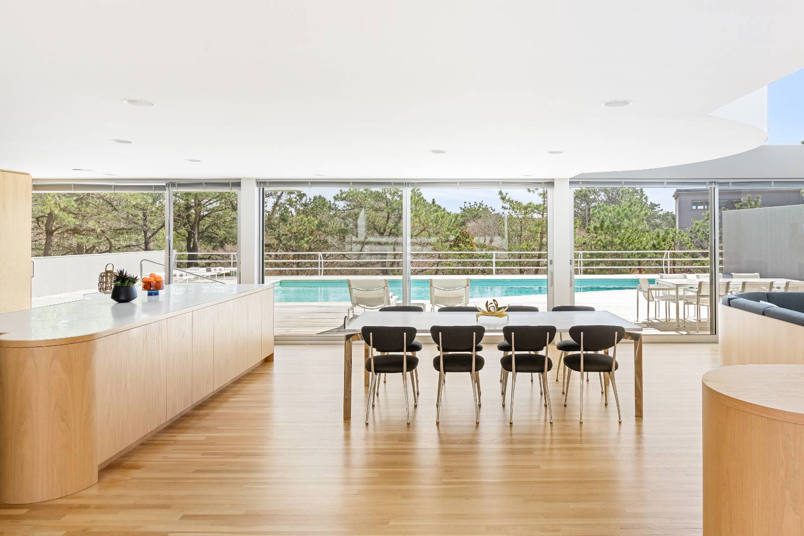 43 Gilberts Path Amagansett, NY 11930 - Photo 4 of 38 a dining room with wooden floor a glass table and a large window
