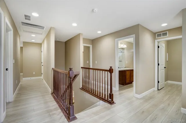 a view of a hallway with wooden floor and windows