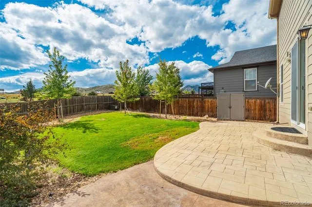a backyard of a house with plants and wooden fence