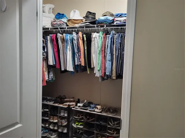 a view of walk in closet with clothes