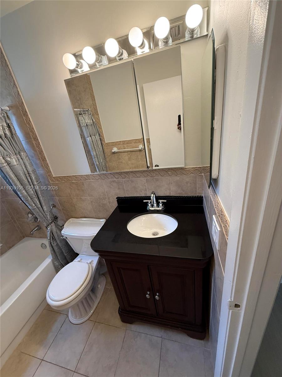 7808 Northwest 60th Street Tamarac, FL 33321 - Photo 21 of 26 a bathroom with a sink a toilet and a mirror