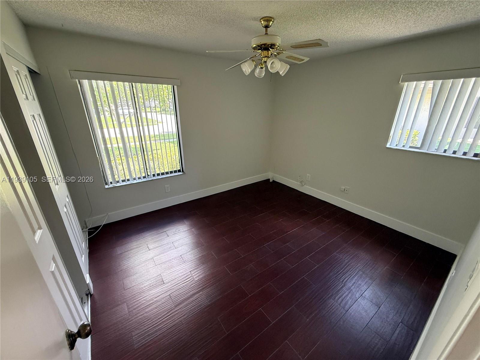 7808 Northwest 60th Street Tamarac, FL 33321 - Photo 26 of 26 an empty room with wooden floor and windows