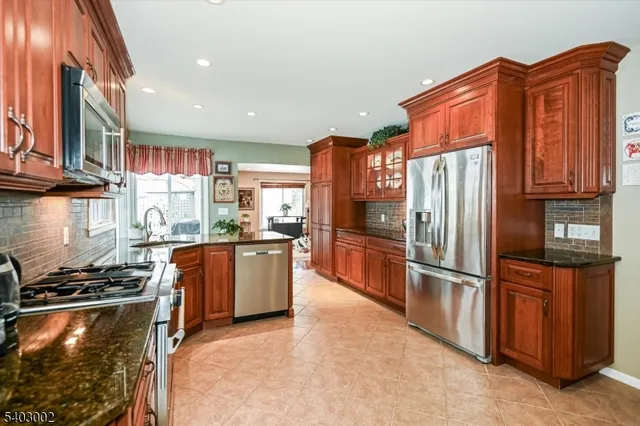 a kitchen with stainless steel appliances granite countertop a refrigerator and a stove
