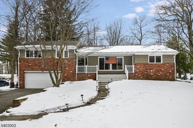 a view of a house with a yard covered in snow