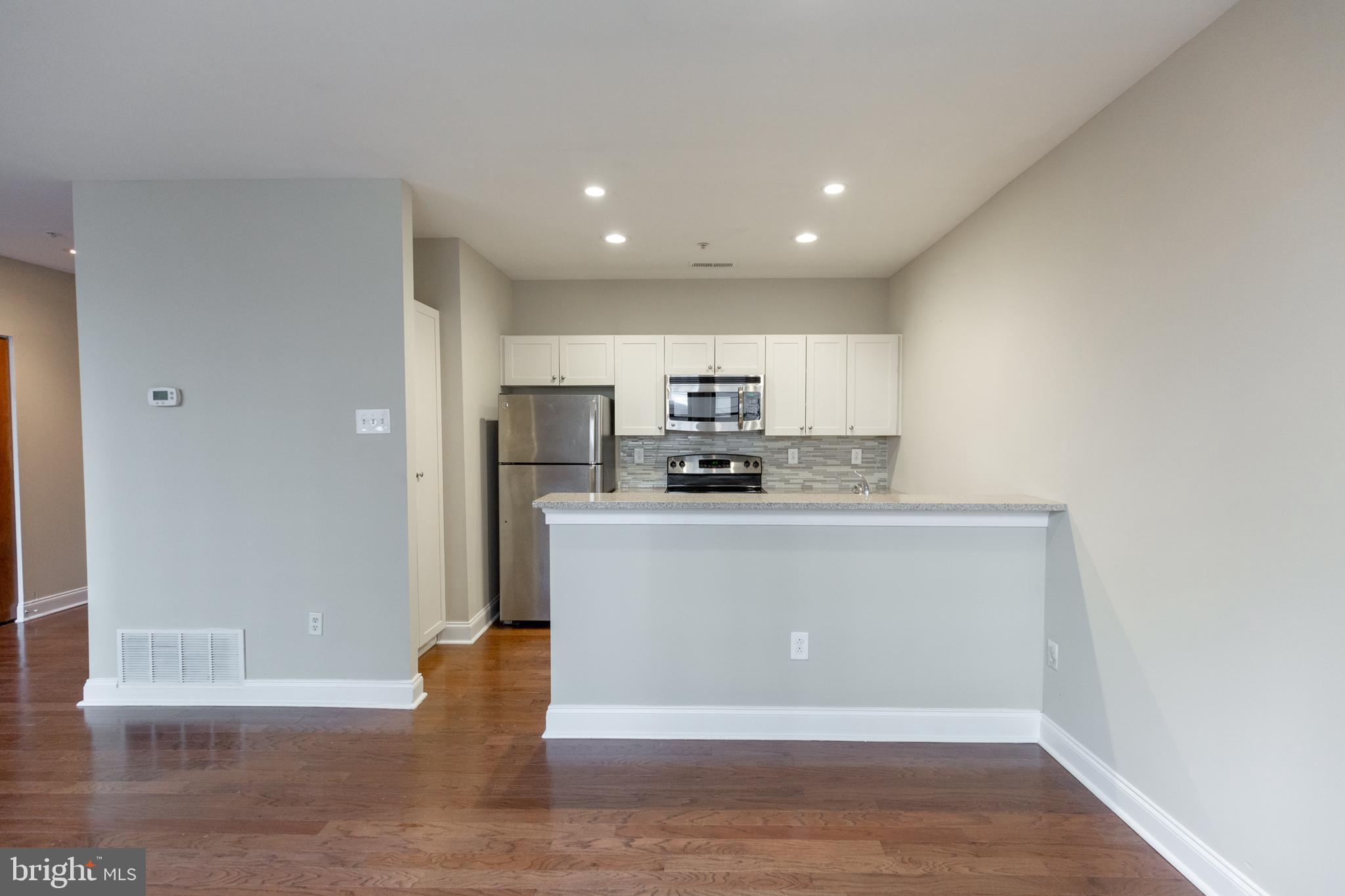 1411-1 Walnut Street, Unit 1005 Philadelphia, PA 19102 - Photo 12 of 27 a view of a kitchen with wooden floor and electronic appliances