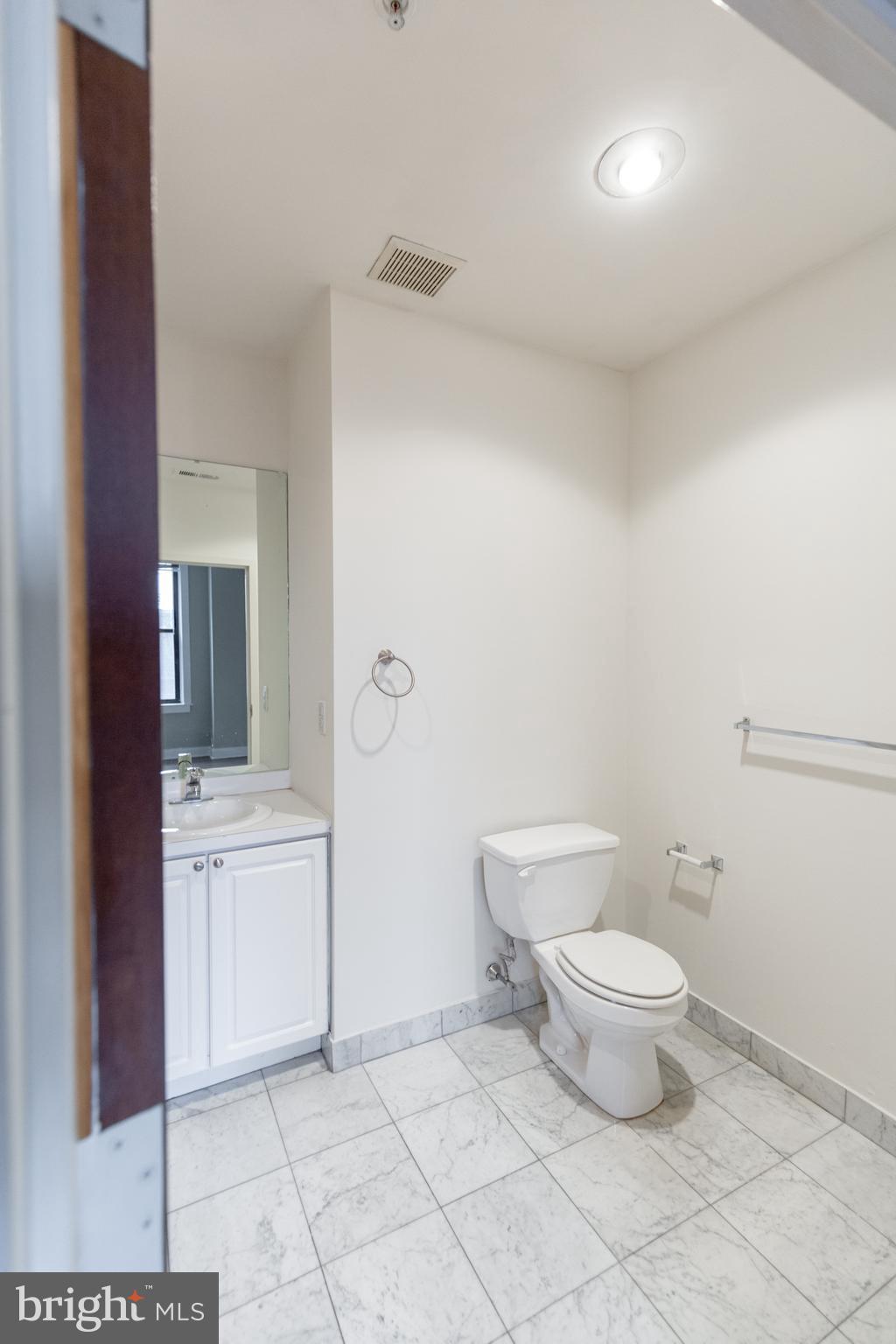 1411-1 Walnut Street, Unit 1005 Philadelphia, PA 19102 - Photo 23 of 27 a bathroom with a toilet a sink and mirror