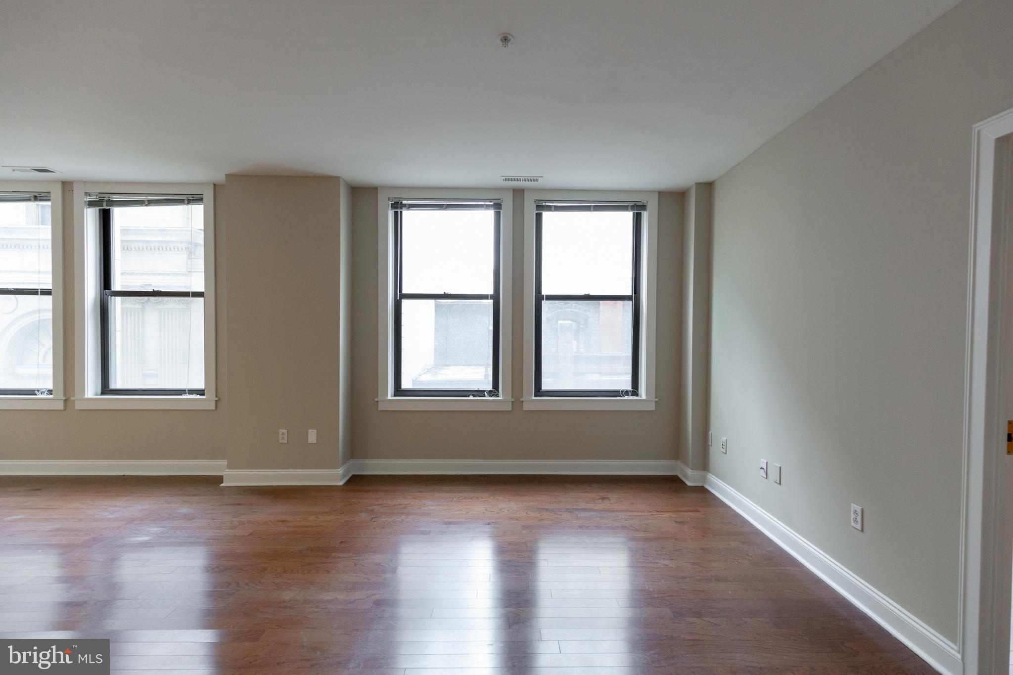 1411-1 Walnut Street, Unit 1005 Philadelphia, PA 19102 - Photo 8 of 27 an empty room with wooden floor and windows