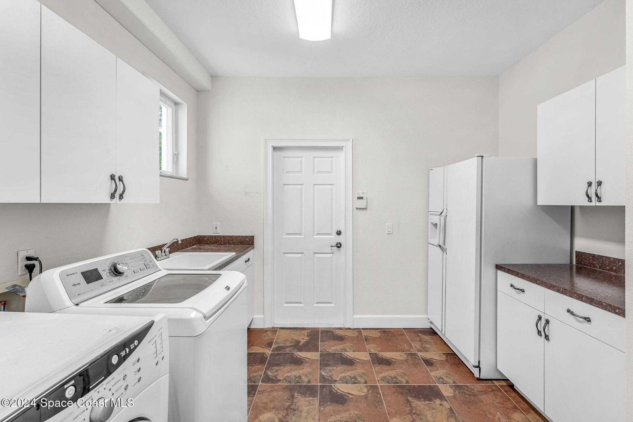 1600 Elm Drive West Melbourne, FL 32935 - Photo 35 of 79 a kitchen that has a sink a refrigerator and cabinets