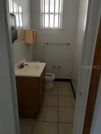 a bathroom with a sink toilet and window