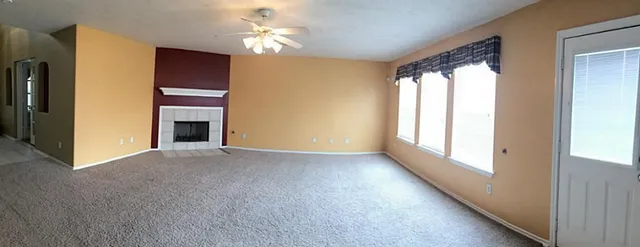 a view of empty room with a fireplace