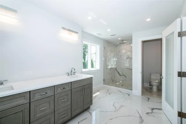 a spacious bathroom with a shower sink mirror and toilet