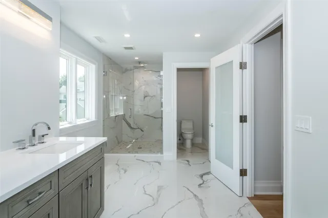 a bathroom with a shower sink and mirror