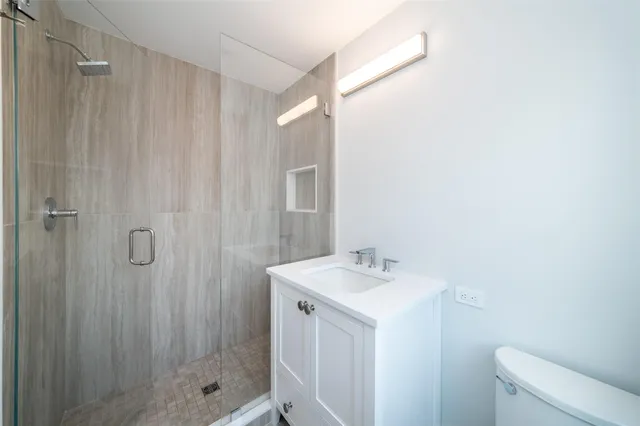 a bathroom with a sink a toilet and shower