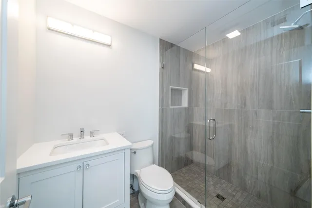 a bathroom with a sink a toilet and shower