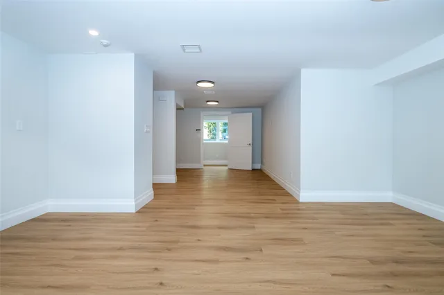 a view of empty room with wooden floor