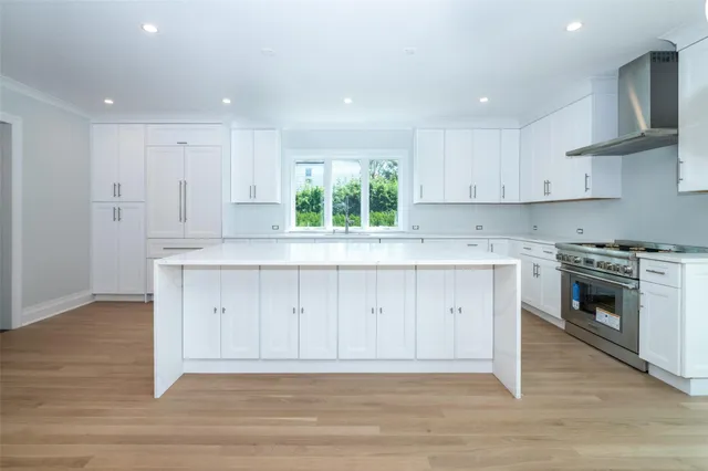 a view of kitchen with wooden floor sink and stainless steel appliances