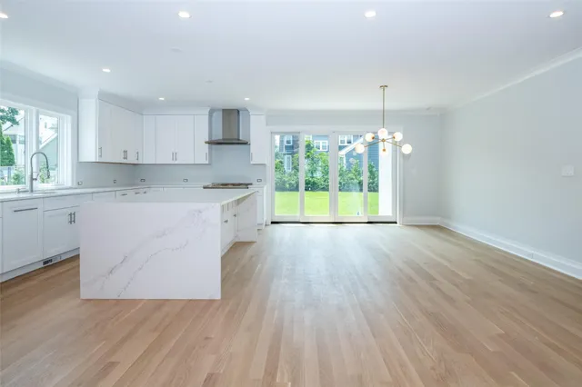 a kitchen with a wooden floor window and cabinets