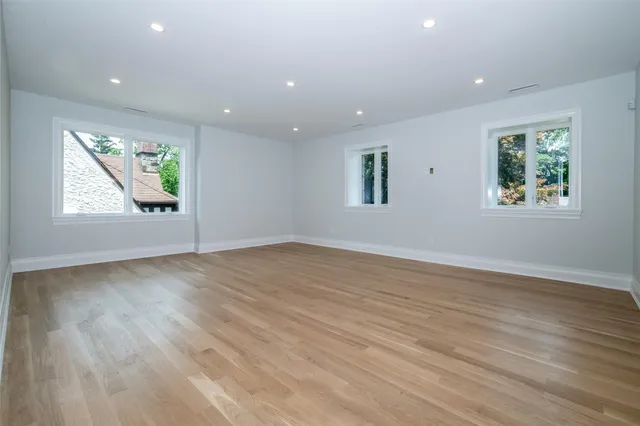 an empty room with wooden floor and window