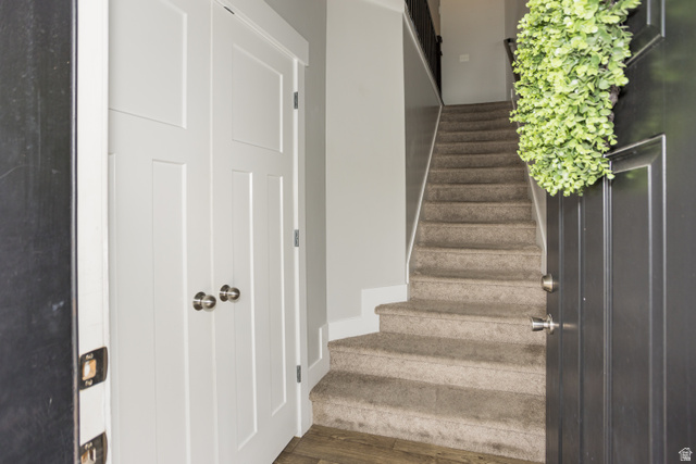 2452 West 500 South, Unit 2 Springville, UT 84663 - Photo 3 of 23 Entryway featuring wood-finish flooring, a carpeted staircase with a dark banister, and a white paneled closet