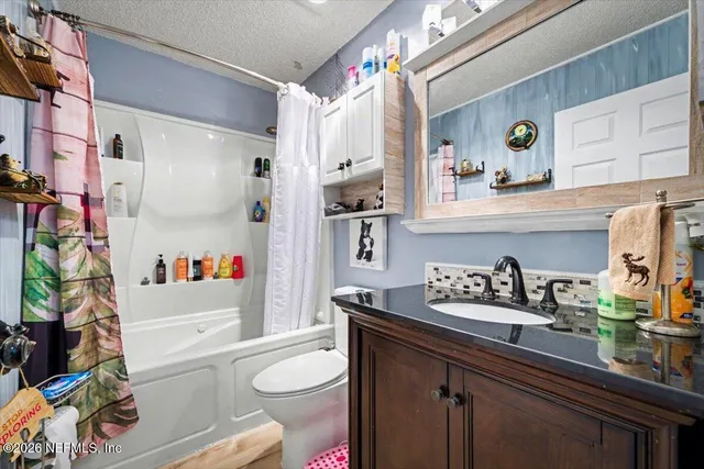 a bathroom with a sink a toilet and a shower curtain