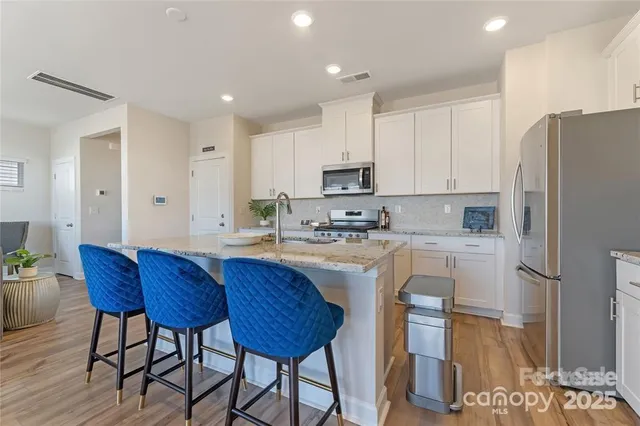 a kitchen with stainless steel appliances granite countertop a sink refrigerator and cabinets