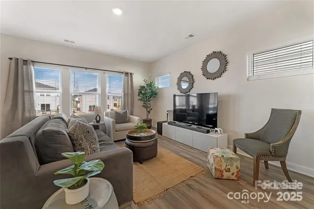 a living room with furniture a large window and a fireplace