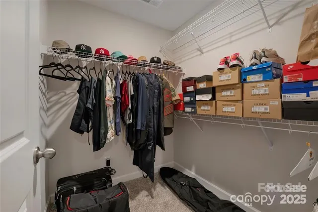 a view of walk in closet with clothes and shoes