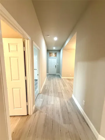 a view of a hallway with wooden floor and closet
