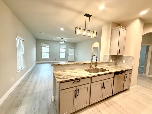 a large kitchen with stainless steel appliances granite countertop a sink and a counter space