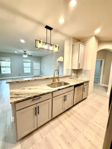 a large kitchen with a large counter top stainless steel appliances and cabinets