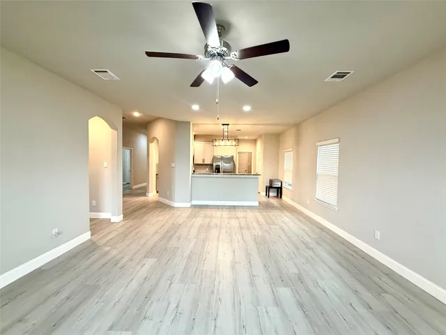 a kitchen with kitchen island stainless steel appliances a sink stove refrigerator and cabinets