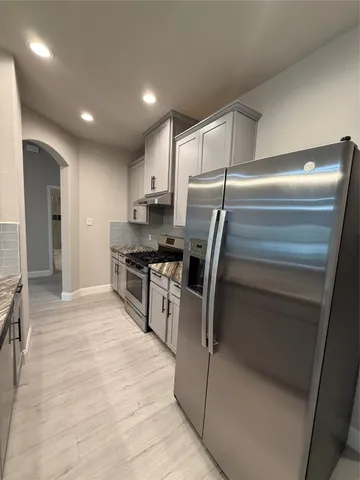 an empty room with wooden floor and a ceiling fan