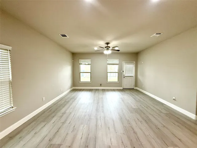 an empty room with wooden floor and white walls