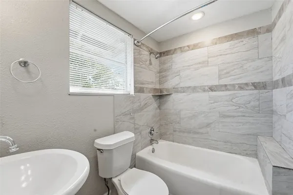 a white bath tub sitting next to a white toilet and sink