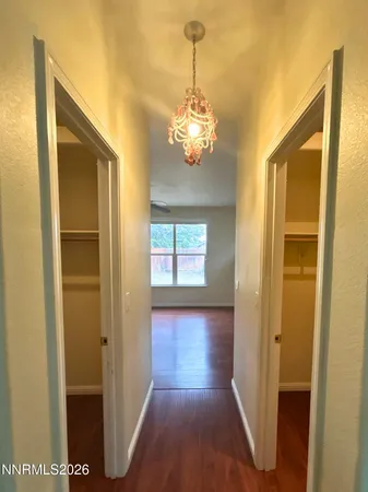 a view of a hallway with wooden floor and a dining room