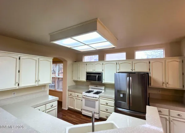 a kitchen with stainless steel appliances kitchen island granite countertop a refrigerator stove microwave and sink