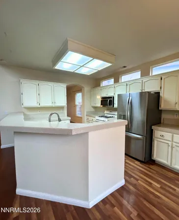a kitchen with a sink stainless steel appliances a refrigerator and cabinets